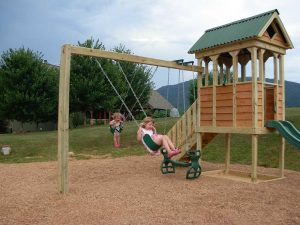 Fort with attached swing beam, stairs going up and slide on the other side - Asheville Playgrounds
