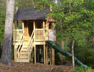 Playhouse mimics the porch and bay windows of the house - Asheville Playgrounds