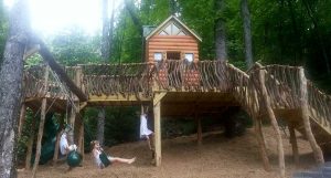 Rustic playground log cabin on a steep hill - Asheville Playgrounds