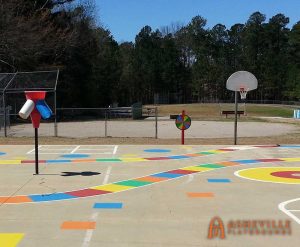 Outdoor game spinner with painted game board on concrete - Asheville Playgrounds